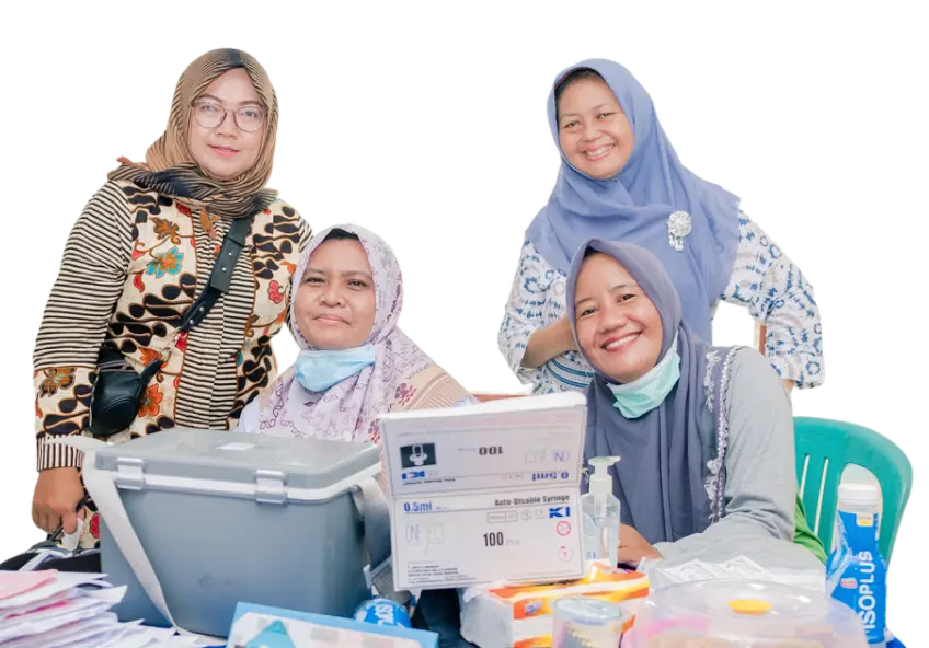 Empat kader kesehatan sedang berpose bersama di meja layanan kesehatan yang dilengkapi dengan peralatan medis, berupa maskes, hand sanitizer dan tisu. Foto ini menunjukkan kepedulian kader dalam memberikan pelayanan kesehatan